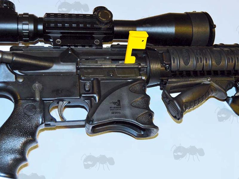 Yellow Plastic Safety Flag Fitted To An AR Rifle Chamber
