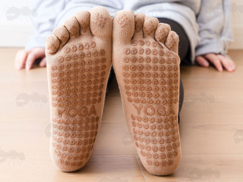 Pair of Beige Yoga Non-Slip Toe Socks Being Modelled