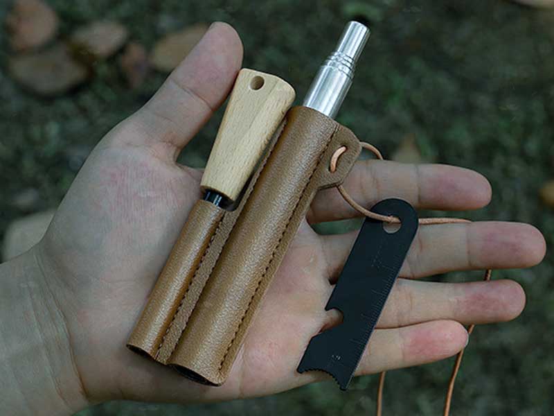 View of The Magnesium Fire Starting Rod with Black Striker Steel and Telescopic Blower in a Faux Leather Sheath in Hand