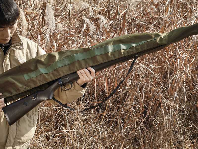 Green Coloured Elastic Rifle Cover Slip Bag with Elasticated Rim for Gun with Silencer, Scope and Bipod Fitted, Being Fitted Over a Bolt Action Rifle