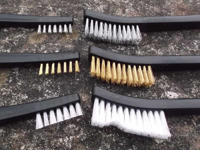 Close-Up View of The Large and Small Heads on The Three Straight Black Handle Gun Cleaning Brushes with Bronze, Stainless Steel and White Nylon Bristles