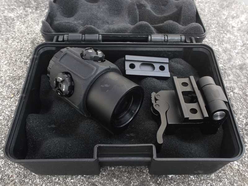 Dot Sight Miniaturised Magnifier with x3 Magnification, with a Flip To The Side Picatinny Rail Base Mount, Shown in Hard Plastic Storage Case with Wave Foam Padding